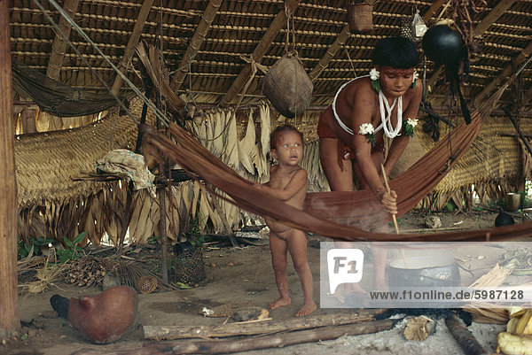 Yanomami Inderin Kochen  rühren Topf  mit Kleinkind in der Nähe  Brasilien  Südamerika