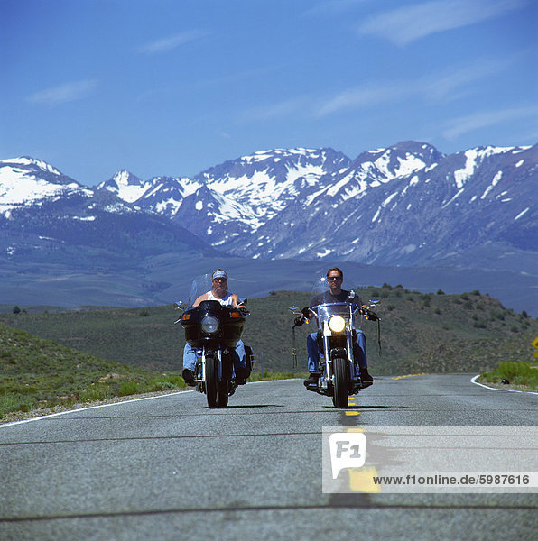 Harley Davidson Biker mit schneebedeckten Bergen im Hintergrund  Vereinigte Staaten von Amerika  Nordamerika