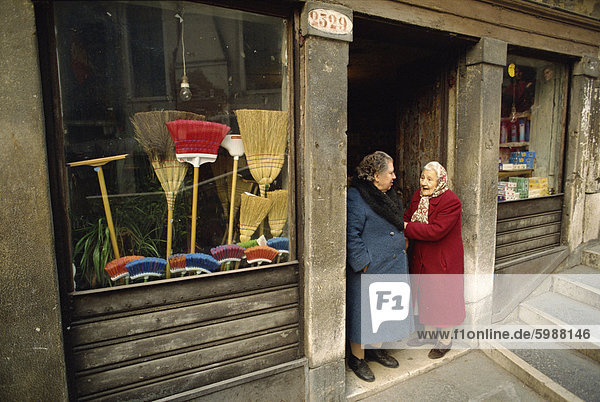 Zwei alte Damen sprechen in der Tür ein Besen-Geschäft in Venedig  Veneto  Italien  Europa