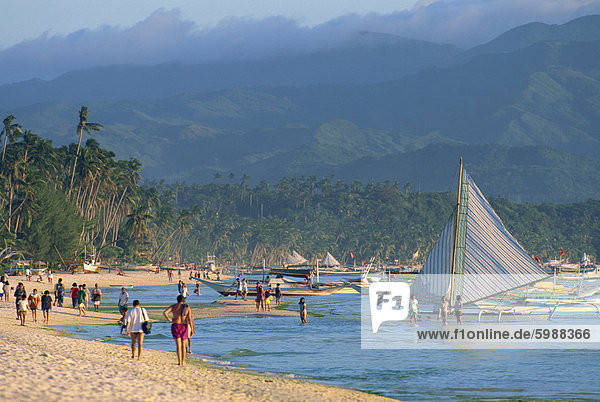Tourists and outrigger canoes on White Sun Beach  at the resort of Boracay Island  off Panay  the Philippines  Southeast Asia  Asia