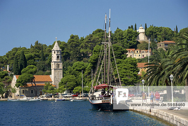 Segelboot am Wasser  mit Bäumen und Kirche im Hintergrund von Cavtat  dalmatinische Küste  Kroatien  Europa