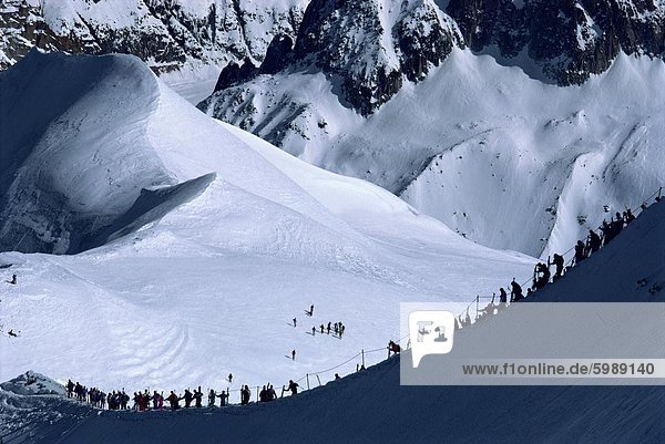 Figures silhouetted walking along the ridge at the top of the Vallee Blanche  Mont Blanc  Chamonix  Rhone Alpes  France  Europe