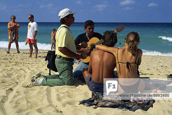 Couple sitting on the beach listening to two musicians  La Habana  Cuba  West Indies  Central America