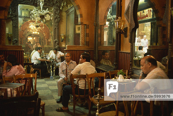 Männer rauchen shisha im Inneren des El Fishawy Kaffeehaus in Khan al-Kalili Bazar in Kairo  Ägypten  Nordafrika  Afrika
