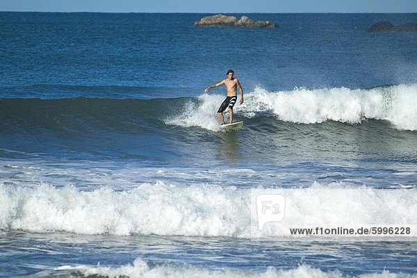 Surfer auf einer Welle  Playa Guiones Strand  Nosara  Nicoya Halbinsel  Provinz Guanacaste  Costa Rica  Mittelamerika