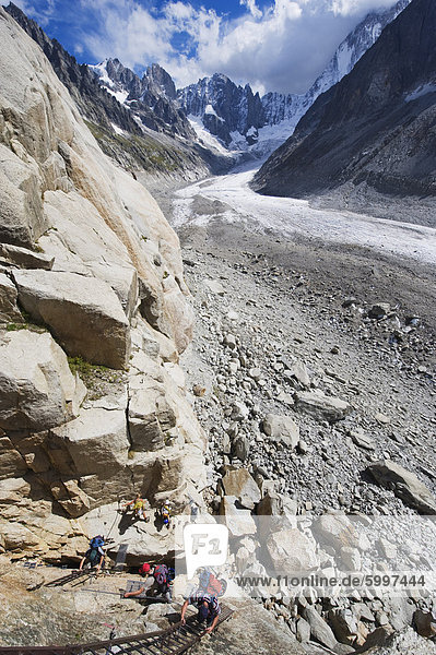 Kletterer auf einer Leiter auf einer Felswand über dem Mer de Glace  Mont Blanc Massiv  Chamonix  französische Alpen  Frankreich  Europa
