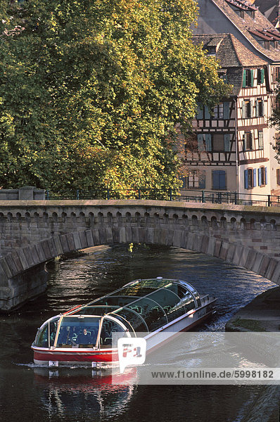 Touristenboot unter Bogen des Ponts Couverts (Gedeckte Brücken) datierend aus dem 14. Jahrhundert  über Fluss Ill  mit im Viertel Petite France hinter  Grande Ile  UNESCO-Weltkulturerbe  Straßburg  Elsass  Frankreich  Europa