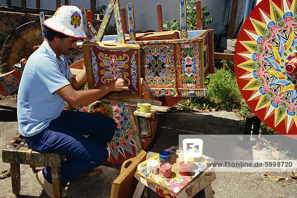 Portrait of a man with his paint pots painting traditional designs  at Sarchi in Costa Rica  Central America
