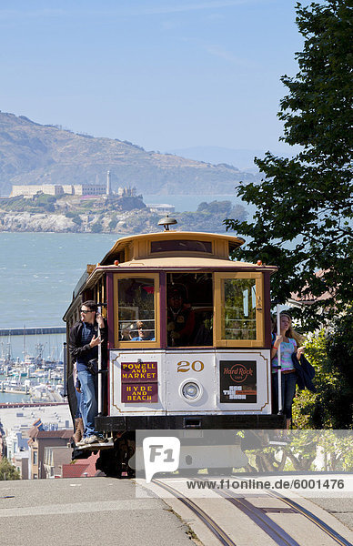 One of the famous cable cars on the Powell-Hyde track  with the island prison of Alcatraz in the background  San Francisco  California  United States of America  North America
