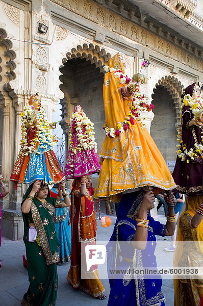 Sari bekleideten Frauen  die Idole auf dem Mewar-Festival in Udaipur  Rajasthan  Indien  Asien