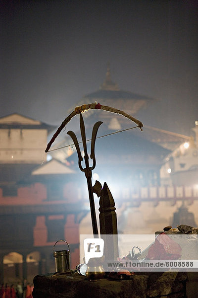 Ein Heiliger Mann Bogen gebrachten eine Bronzeskulptur von einem Shiva-Dreizack  Hindu-fest Shivaratri  Pashupatinath  Kathmandu  Nepal  Asien