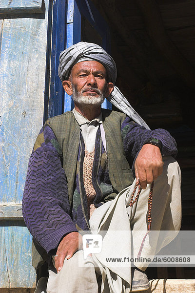Portrait of a man sitting in doorway  Syadara  between Yakawlang and Daulitiar  Afghanistan  Asia