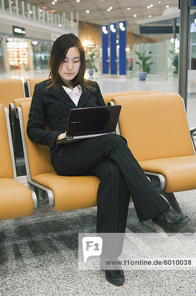Eine chinesische geschäftsfrau mit einen Laptopcomputer am Beijing Capital Airport Teil des neuen Terminal 3 Gebäude eröffnete Februar 2008  zweitgrößte Gebäude der Welt  Beijing China  Asien
