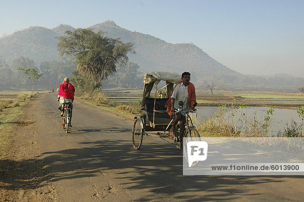Early morning rickshaw wallahs pass each other in rural countryside near Baliguda  Orissa  India  Asia