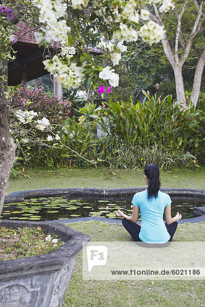 Frau praktizieren Yoga in Taman Tirta Gangga (Wasserschloss)  Tirta Gangga  Bali  Indonesien  Südostasien  Asien