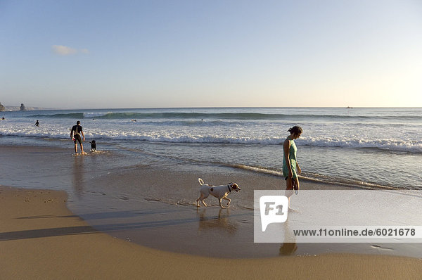 Eine junge Frau geht ihr Hund am Strand Arrifana  Algarve  Portugal  Europa