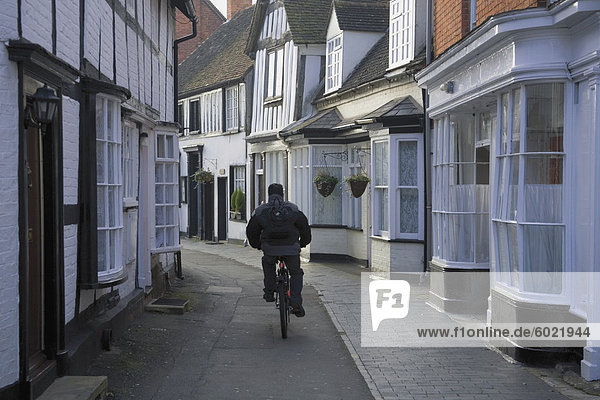 Mann  Radfahren entlang der schmalen Straße  Alcester  Warwickshire  Midlands  England  Vereinigtes Königreich  Europa