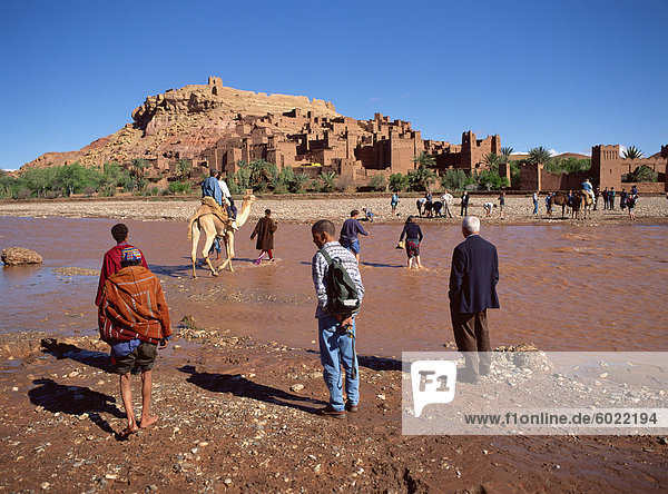 Touristen kreuzen Fluss Asif Mellah Kasbah Ait Ben Haddou  UNESCO-Weltkulturerbe  in der Nähe von Ouarzazate  Marokko  Nordafrika  Afrika zu besuchen