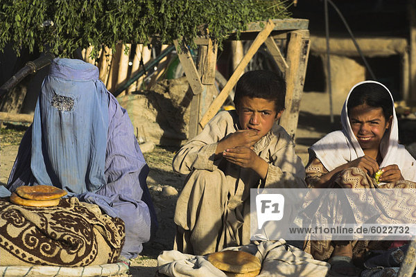 Frau und Kinder verkaufen Brot auf der Straße  Maimana  Provinz Faryab  Afghanistan  Asien