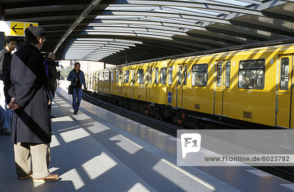 Passagiere auf der Plattform und ein Gelber Zug  Mendelsshon U-Bahnstation  Berlin  Deutschland  Europa
