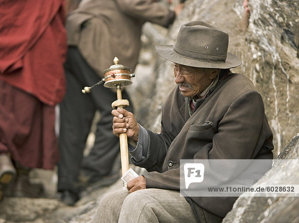 Alter Mann sitzt  betet und hofft auf Spenden auf der buddhistischen Lingkor Schaltung  eine traditionelle Pilgerfahrt um die Heiligen Stätten der Stadt Lhasa  Tibet  China  Asien