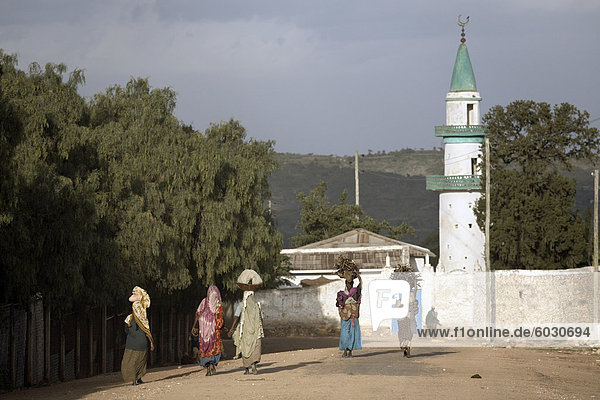 Frauen tragen ihre waren auf ihren Köpfen  in der Nähe einer Moschee in der Stadt Harar  Äthiopien  Afrika