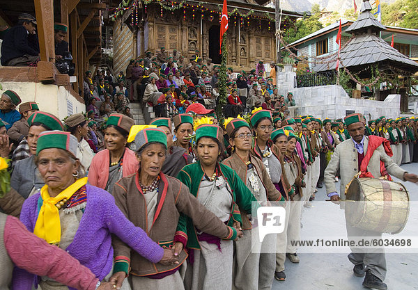 Group of women in full traditional clothes performing traditional dancing in a row with man beating on drum during Ataro religious festival in Baring Narj temple  Sangla  Baspa Valley  Kinnaur  Himachal Pradesh  India  Asia