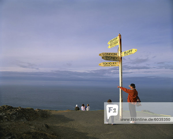 Visitors by the sign at Cape Reinga on the coast of Northland  North Island  New Zealand  Pacific