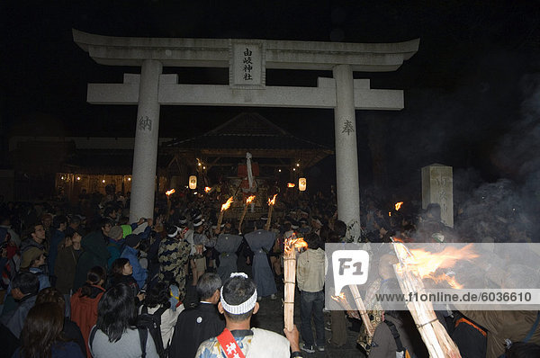Procession of torches and traditional costumes at Hi Matsuri (fire festival) entering shrine through Torii gate  Kurama village  Kyoto  Japan  Asia