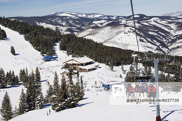 Skiers being carried on a chair lift to the back bowls of Vail ski resort  Vail  Colorado  United States of America  North America