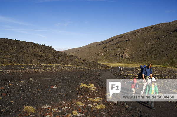 A family walking the Tongariro Crossing  Tongariro National Park  the oldest national park in the country  UNESCO World Heritage Site  Taupo Volcanic Zone  North Island  New Zealand  Pacific