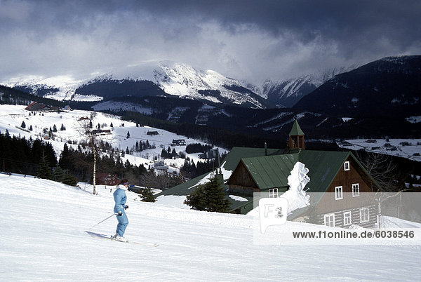 Winterliche Ansicht des Skifahrers auf Pisten in Pec Pod Snezkou mit Schneekoppe (1602m) im Hintergrund  Riesengebirge  Bohemia  Tschechische Republik  Europa