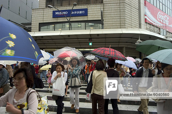 Fußgänger überqueren im Regen  Stadt Kyoto  der Insel Honshu  Japan  Asien