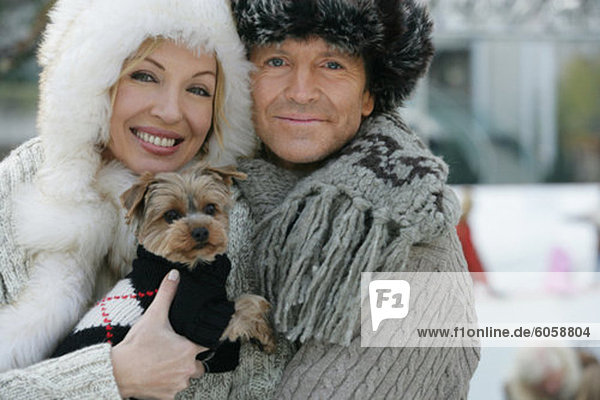 Mature couple holding a Yorkshire Terrier