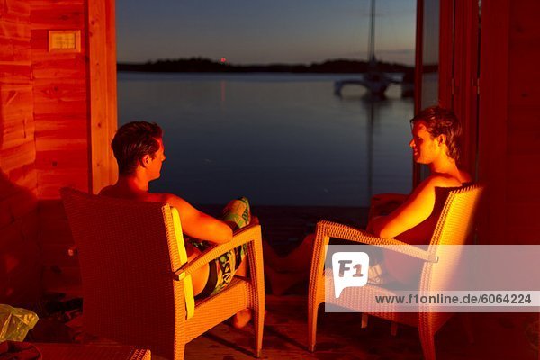 Zwei junge Männer entspannend auf Stühlen auf dem Seeweg