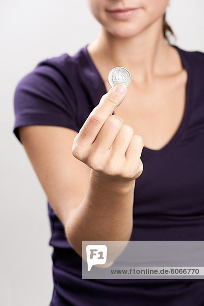 Eine Frau hält eine Münze