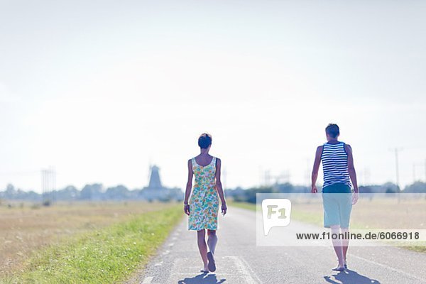 Woman and man walking on country road