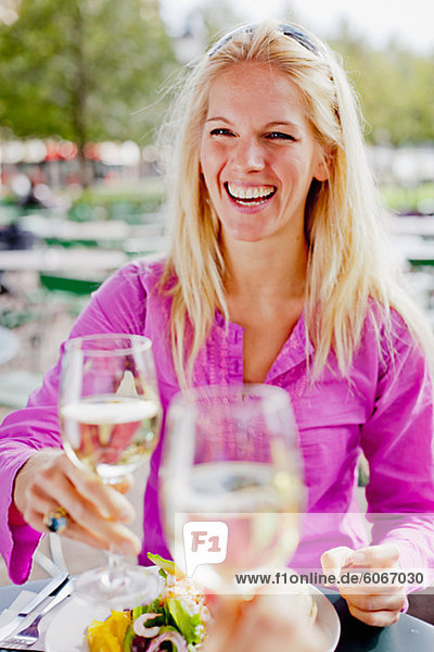Woman holding wine glass at outdoor cafe