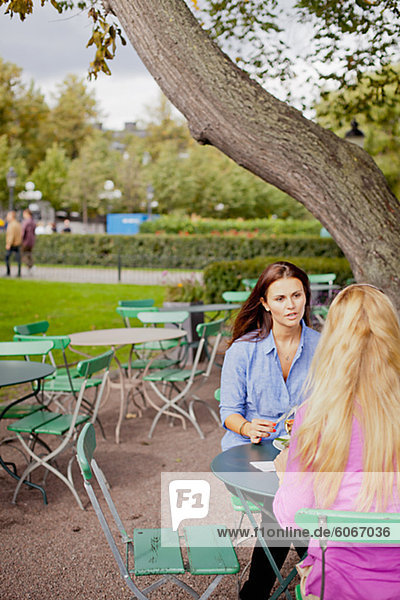 Zwei Frauen sitzen im Café im freien