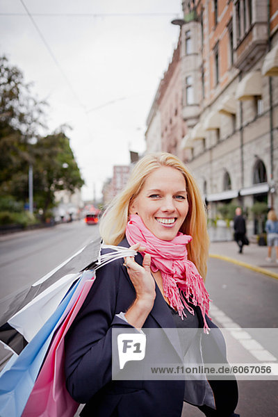 Portrait of woman with shopping bags in street