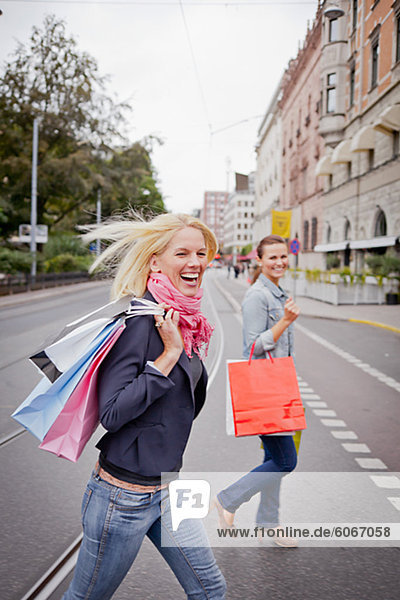 Portrait of two women with shopping bags in street