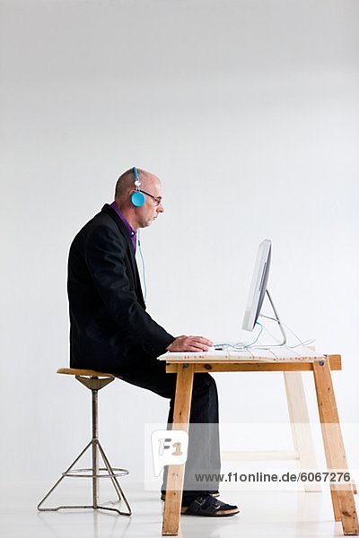 Kaufmann  Kopfhörer  hören mit Computer am Schreibtisch