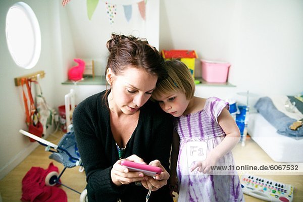 Mutter mit Tochter Blick auf Handy