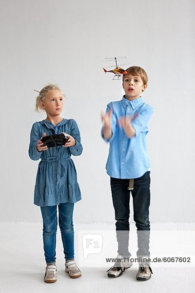 Junge und Mädchen spielen mit Hubschraubermodell