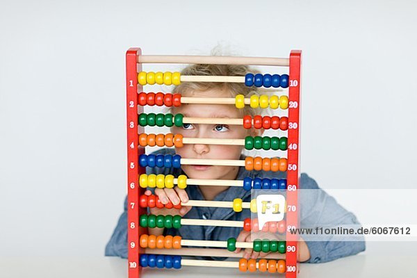 Girl hiding behind colorful abacus