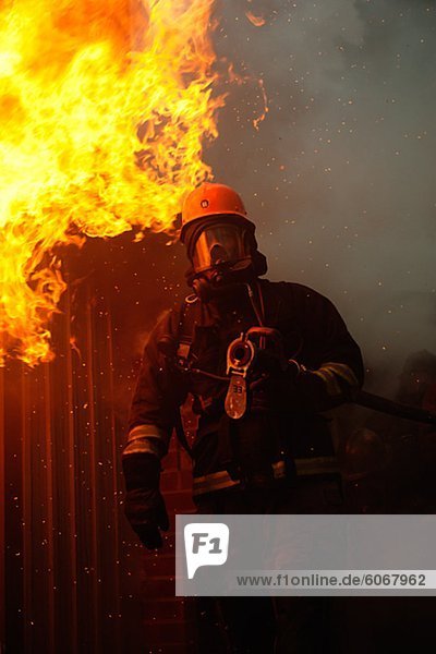 Feuerwehrmann vor Gebäude auf Feuer