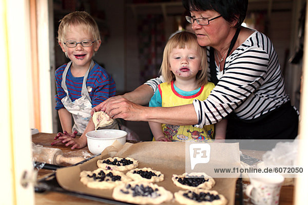 Großmutter mit Enkel Heidelbeere Kuchen backen