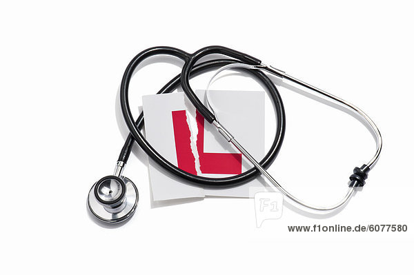 A doctors stethoscope and a torn learners permit sticker