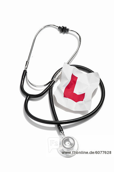 A doctors stethoscope and a crumpled learners permit sticker