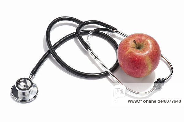 A doctors stethoscope and a red apple